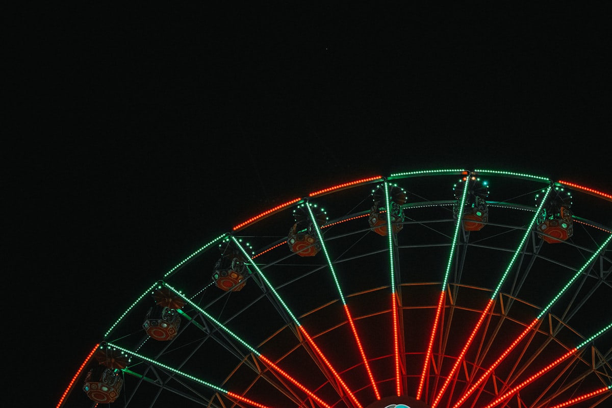 A lit wheel turning against the night sky